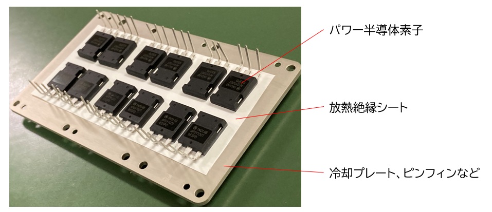 三菱ケミカルの高放熱絶縁樹脂シートをパワーモジュールの冷却器へ貼り合わせた写真
